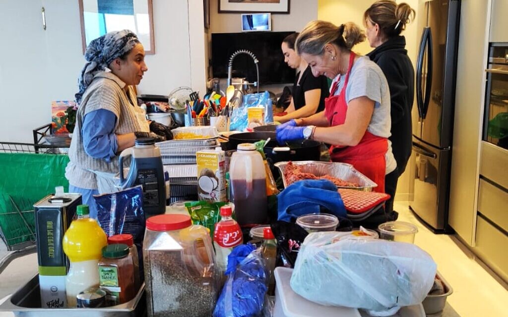 Volunteers preparing food at Shekoufeh 'Chicki' Elghanian's Herzliya apartment, on December 28, 2023. (Gavriel Fiske/TOI)