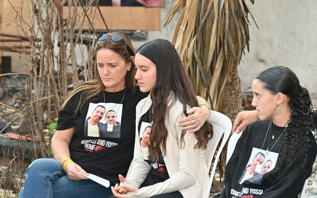 Oren Sharabi, right, sits near her sister Ofir and mother Nira in Be'eri on January 1, 2024. (Canaan Lidor/Times of Israel)