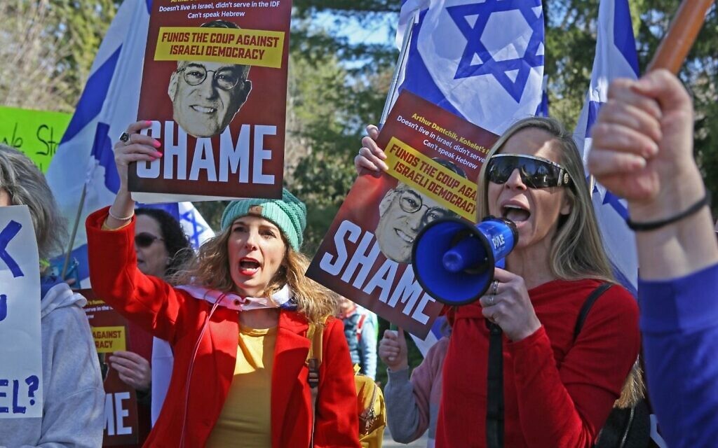 Protesters demonstrating against the Kohelet Policy Forum carry placards criticizing Arthur Dantchik near Dantchik's home in suburban Philadelphia on March 26, 2023. (Roy Boshi)