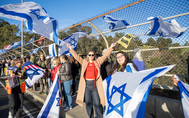 Yoav Harlev and hundreds of others demonstrate on behalf of the Hamas-held hostages on the El Curtola highway overpass on the 100th day of the Israel-Hamas war, January 14, 2024. (Thomas Smith/Bay Area Telegraph)