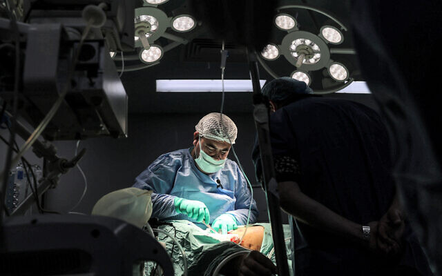 A surgeon operates on a patient in a surgery operating theatre at the Gaza European Hospital in Khan Yunis in the southern Gaza Strip on December 31, 2023. (AFP)