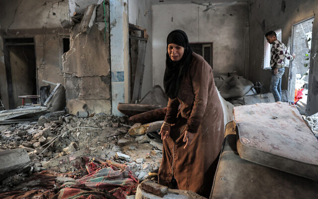 A Palestinian woman cries as she inspects a heavily damaged apartment following Israeli bombardment on Rafah in the southern Gaza Strip on February 8, 2024. (Said Khatib/AFP)