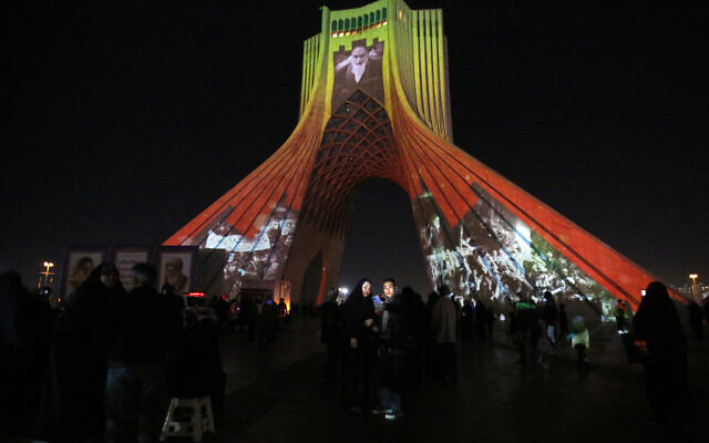 Azadi (Freedom) Tower is illuminated with pictures of Iranian late supreme leader Ayatollah Ruhollah Khomeini and Iran's national flag during a ceremony for the 45th anniversary of the Islamic Revolution, in Tehran, February 10, 2024. (AFP)