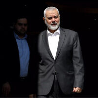 This handout picture provided by the Iranian foreign ministry on February 13, 2024, shows Hamas' political bureau chief Ismail Haniyeh preparing to welcome the Iranian Foreign Minister in Doha. (Iranian Foreign Ministry/AFP)