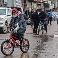 A man rides a bicycle in Rafah in southern Gaza, on February 18, 2024. (SAID KHATIB / AFP)
