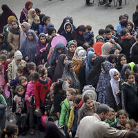 Displaced Palestinians gather to receive food at a government school in Rafah in the southern Gaza Strip on February 19, 2024. (Mohammed Abed/AFP)