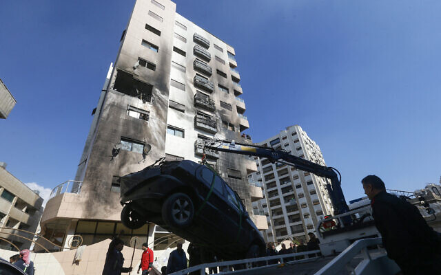 A car is removed from the area where reported Israeli airstrikes targeted an apartment in a residential building in the Kafr Sousa district of the Syrian capital Damascus on February 21, 2024.(Photo by LOUAI BESHARA / AFP)