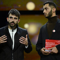 Israeli director Yuval Abraham (L) and Palestinian director Basel Adra speak on stage after having received the Berlinale documentary award for 'No Other Land' during the awards ceremony of the 74th Berlinale International Film Festival, on February 24, 2024 in Berlin. (John MacDougall/AFP)