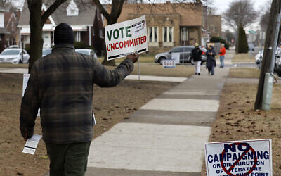 A volunteer asks people to vote uncommitted, instead of for US President Joe Biden, outside of McDonald Elementary School in Dearborn during the Michigan presidential primary election on February 27, 2024. (JEFF KOWALSKY / AFP)