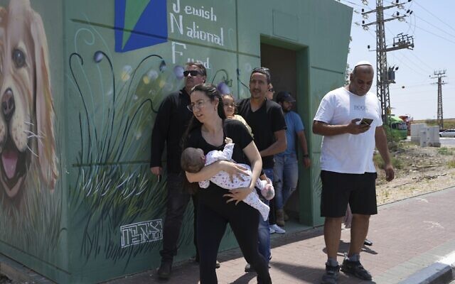 Residents of Sderot emerge from the public bomb shelter in between missile strikes, May 10, 2023. (Tsafrir Abayov/AP)