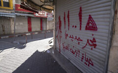 Palestinian shops are closed during a general strike in solidarity with Gaza at the commercial center of the West Bank city of Ramallah, December 11, 2023. Arabic reads 'A new dawn in the life of the Arab nation.' (Nasser Nasser/AP)
