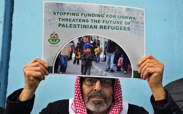 A Palestinian Hamas supporter holds a placard with the terror group's logo during a protest demanding that UNRWA staff who were fired in the Gaza Strip after allegedly taking part in the October 7 atrocities be returned to their jobs and that countries resume funding of the agency, in front of the United Nations Relief and Works Agency headquarters in Beirut, Lebanon, January 30, 2024. (AP Photo/Bilal Hussein)
