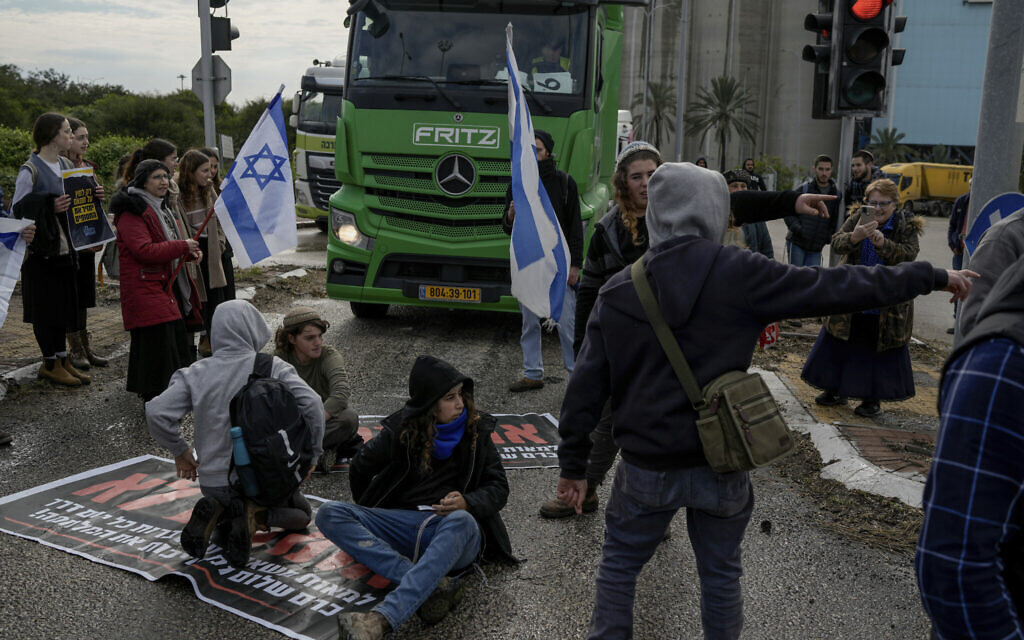 Israeli activists block the exit of Ashdod port to stop trucks they claim are carrying humanitarian aid destined for the Gaza Strip, in Ashdod, Israel, Thursday, Feb. 1, 2024. (AP/Leo Correa)
