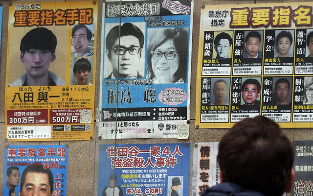 A wanted poster, center top. for Satoshi Kirishima, a fugitive who has long been wanted for one of a series of terrorist bombings in Japan, is displayed outside a police station Friday, Feb. 2, 2024, in Tokyo. (AP Photo/Eugene Hoshiko)