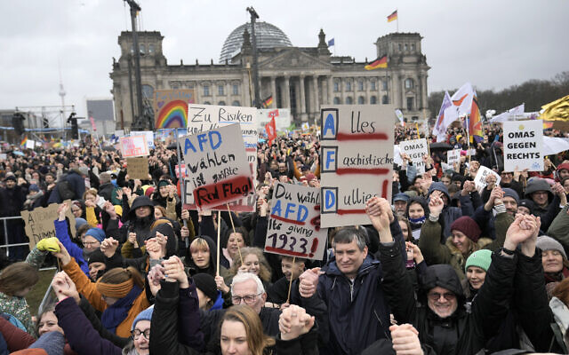 People hold hands in front of Germany's parliament Reichstag at a demonstration against the AfD party and right-wing extremism in Berlin, Germany, Saturday, Feb. 3, 2024. (AP Photo/Ebrahim Noroozi)