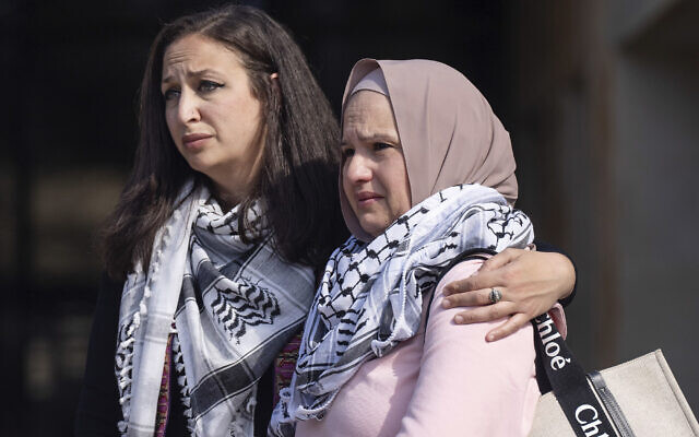 Shaimaa Zayan, left, holds Odi Doar, the mother of stabbing victim Zacharia Doar, as they stand near the podium during a press conference outside City Hall, Tuesday, Feb. 6, 2024, in Austin, Texas.  (Mikala Compton/Austin American-Statesman via AP)