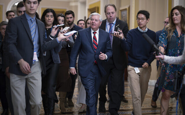 With reporters seeking comment, Sen. Lindsey Graham, R-S.C., walks to the chamber during a test vote to begin debate on a border security bill, at the Capitol in Washington, Wednesday, Feb. 7, 2024. (AP Photo/J. Scott Applewhite)