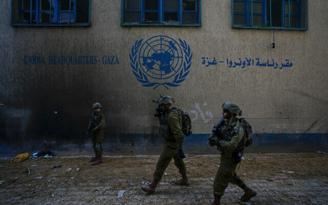 Israeli soldiers take position as they enter UNRWA headquarters in Gaza City where the military discovered tunnels and a secret data center underneath the UN agency, February 8, 2024. (AP/Ariel Schalit)