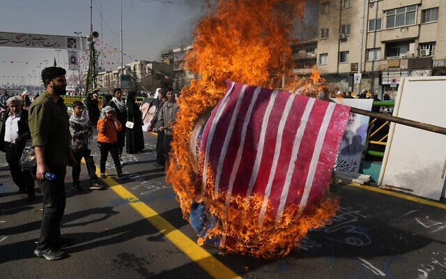 Demonstrators burn representations of the Israeli and US flags during their annual rally commemorating Iran's 1979 Islamic Revolution in Tehran, Iran, February 11, 2024. (Vahid Salemi/AP)