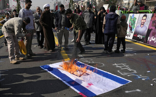 Demonstrators burn a representation of the Israeli flag during their annual rally commemorating Iran's 1979 Islamic Revolution in Tehran, Iran, February 11, 2024. (Vahid Salemi/AP)
