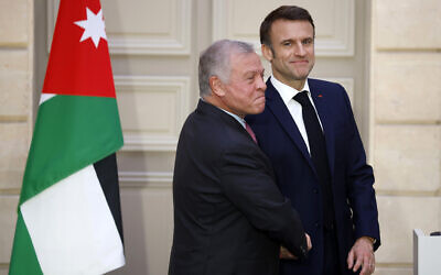 French President Emmanuel Macron, right, greets Jordan's King Abdullah II following their statement Friday, February 16, 2024 at the Elysee Palace in Paris. (Yoan Valat, Pool via AP)