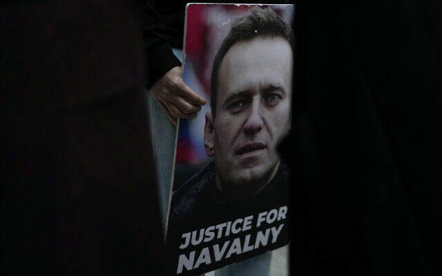 A person holds a picture of Russian opposition leader Alexei Navalny during a vigil in front of the Russian embassy in Lisbon, Friday, Feb. 16, 2024. (AP Photo/Armando Franca)