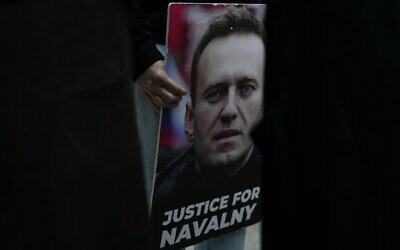 A person holds a picture of Russian opposition leader Alexei Navalny during a vigil in front of the Russian embassy in Lisbon, Friday, February 16, 2024. (AP Photo/Armando Franca)