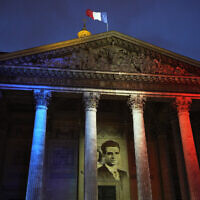 The portrait of Missak Manouchian is projected on the facade of the Pantheon monument in Paris, France, Feb. 21, 2024. (AP Photo/Michel Euler)