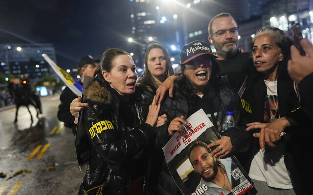 Former hostage Ilana Grisewsky, center, takes part in a protest in Tel Aviv calling on the government to return the remaining abductees held by Hamas in Gaza, on February 24, 2024. The protesters merged with anti-government demonstrators, prompting police to use water cannons to disperse the crowds. (AP Photo/Ohad Zwigenberg)