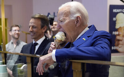 US President Joe Biden eats ice cream at Van Leeuwen Ice Cream, February 26, 2024, in New York, as Seth Meyers watches. (AP Photo/Evan Vucci)