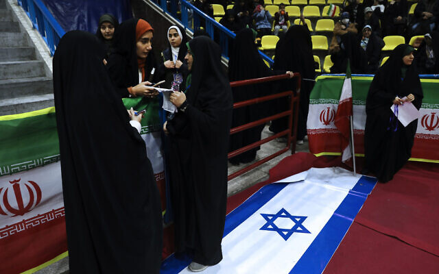 Iranian women attend an election campaign rally ahead of the March 1, parliamentary and Assembly of Experts elections as a representation of the Israeli flag is placed on the ground, in Tehran, Iran, February 27, 2024. (Vahid Salemi/AP)