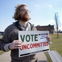 Eric Suter-Bull holds a Vote Uncommitted sign outside a voting location at Saline Intermediate School for the Michigan primary election in Dearborn, Michigan, Tuesday, Feb. 27, 2024 (AP Photo/Paul Sancya)