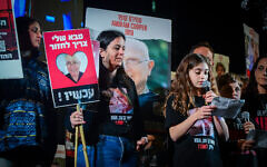 Hili Cooper (with microphone) and Or Nohomovitch (right), tell protesters how they miss their grandfather, Amiram Cooper, held hostage in Gaza, at a rally for the release of Israelis kidnapped by Hamas terrorists, at Hostages Square in Tel Aviv, February 10, 2024. (Avshalom Sassoni/ Flash90)