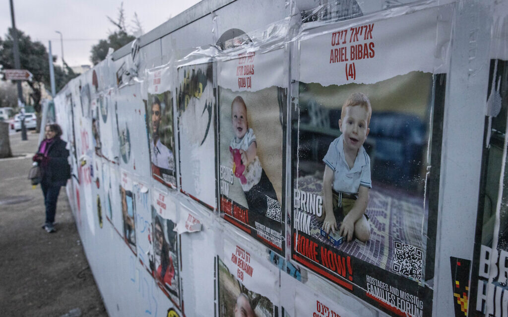 Pictures of the Bibas family, who were taken hostage by Hamas on October 7, hang on a wall outside the Knesset, the Israeli parliament in Jerusalem, February 19, 2024. (Chaim Goldberg/Flash90)
