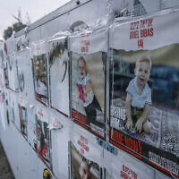 Pictures of the Bibas family, who were taken hostage by Hamas on October 7, hang on a wall outside the Knesset, the Israeli parliament in Jerusalem, February 19, 2024. (Chaim Goldberg/Flash90)