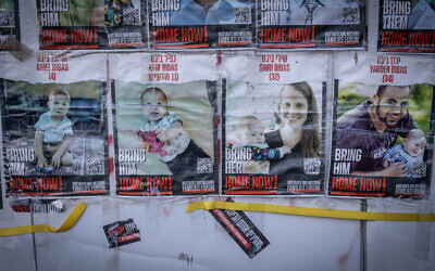 Pictures of the Bibas family hang on a wall outside the Knesset in Jerusalem, February 19, 2024. (Chaim Goldberg/Flash90)