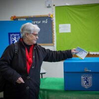 A woman casts her vote at a polling station on the morning of the municipal elections, in Jerusalem, on February 27, 2024 (Yonatan Sindel/Flash90)