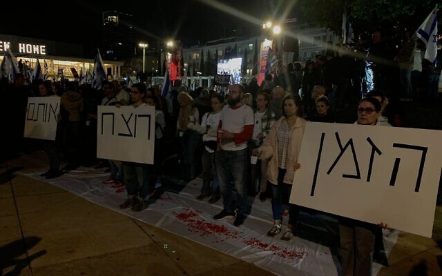 Silent demonstrators stand at Habima Square in Tel Aviv during an anti-government protest on February 10, 2024. (Charlie Summers/Times of Israel)