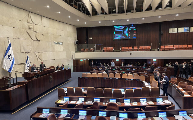 Lawmakers in the Knesset plenum vote on a bill to criminalize the denial of the atrocities committed by Hamas on October 7, February 7, 2024. (Sam Sokol/Times of Israel)