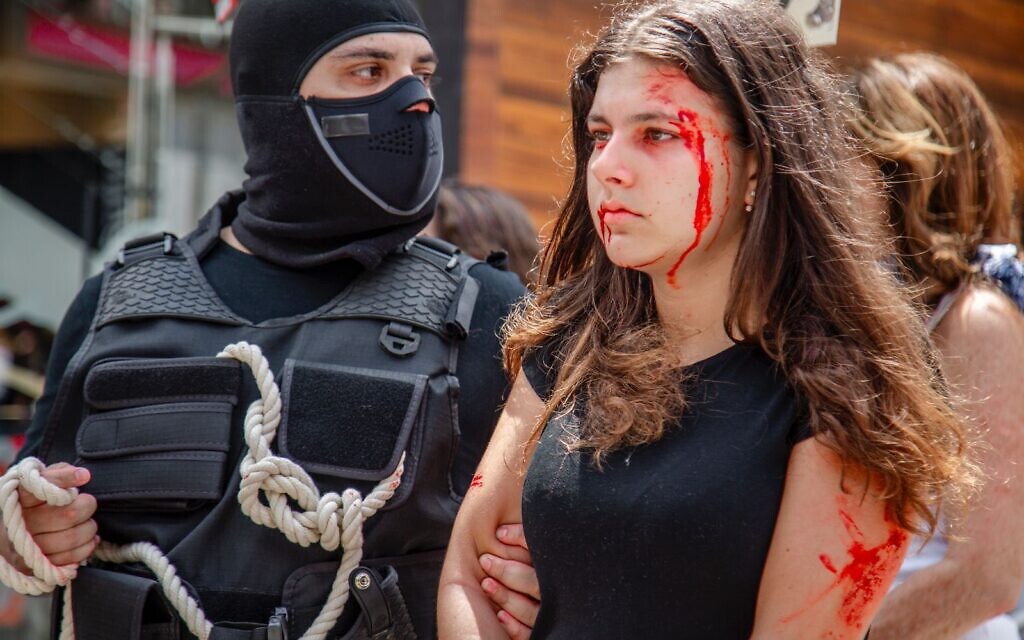 Actress Alessandra Dayan is pulled through the streets of Sao Paulo, Brazil, in a graphic reenactment of the real-life abduction of Naama Levy by Hamas terrorists, November 30, 2023. (Abner Palma/Fisesp)