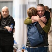 Louis Har (in black) and Fernando Marman reuniting with their loved ones, at Sheba Medical Center, February 12, 2024 (IDF Spokesperson)