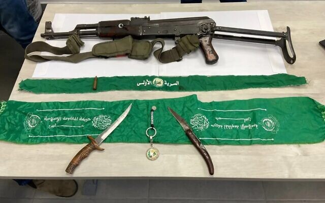 Weapons and Hamas flags captured in an Israeli boarding school, allegedly taken by a teacher who returned from reserve duty in Gaza, February 8, 2024. (Israel Police)