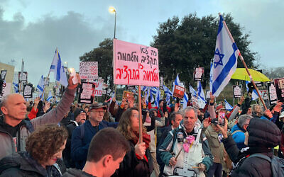 Demonstrators gather outside the Knesset to protest the government's 2024 wartime budget on February 19, 2024. (Charlie Summers/Times of Israel)
