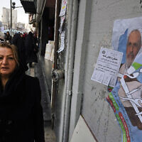 A woman walks past electoral posters of Ayatollah Alireza Arafi, a candidate for the upcoming Assembly of Experts elections in downtown Tehran, Iran, Wednesday, Feb. 21, 2024. (AP Photo/Vahid Salemi)