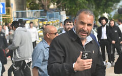 Ron Kobi, holding cellphone, visits a balloting station in Tiberias on February 27, 2024. (Canaan Lidor/Times of Israel)