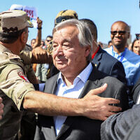 Illustrative: Protesters raise signs in solidarity with Palestinians in the Gaza Strip as Egyptian army officers and bodyguards escort UN Secretary-General Antonio Guterres to his vehicle, during a visit to oversee preparations for the delivery of humanitarian aid to the Palestinian enclave, on the Egyptian side of the Rafah border on October 20, 2023. (Kerolos Salah/AFP)