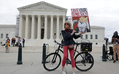 Local resident Nicky Sundt holds a sign that reads 'Save Our Democracy,' in front of the US Supreme Court on March 4, 2024, in Washington, DC. (Alex Wong/ Getty Images/ AFP)
