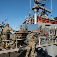 US Army soldiers load an AC unit aboard the USAV Monterey at the pier of the Joint Base Langley-Eustis during a media preview of the 7th Transportation Brigade deployment in Hampton, Virginia, on March 12, 2024. (Roberto Schmidt / AFP)