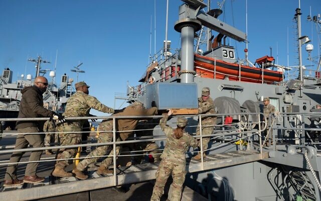 US Army soldiers load an AC unit aboard the USAV Monterey at the pier of the Joint Base Langley-Eustis during a media preview of the 7th Transportation Brigade deployment in Hampton, Virginia, on March 12, 2024. (Roberto Schmidt / AFP)