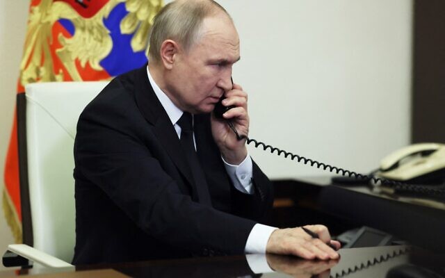 In this pool photograph distributed by the Russian state agency Sputnik, Russia's President Vladimir Putin speaks on the phone in Moscow on March 23, 2024, the day after a gun attack on the Crocus City Hall in Krasnogorsk. (Mikhail METZEL / POOL / AFP)
